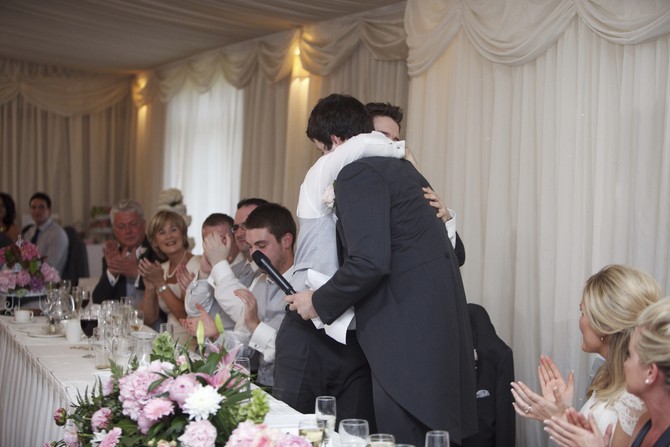father of the bride and groom hugging